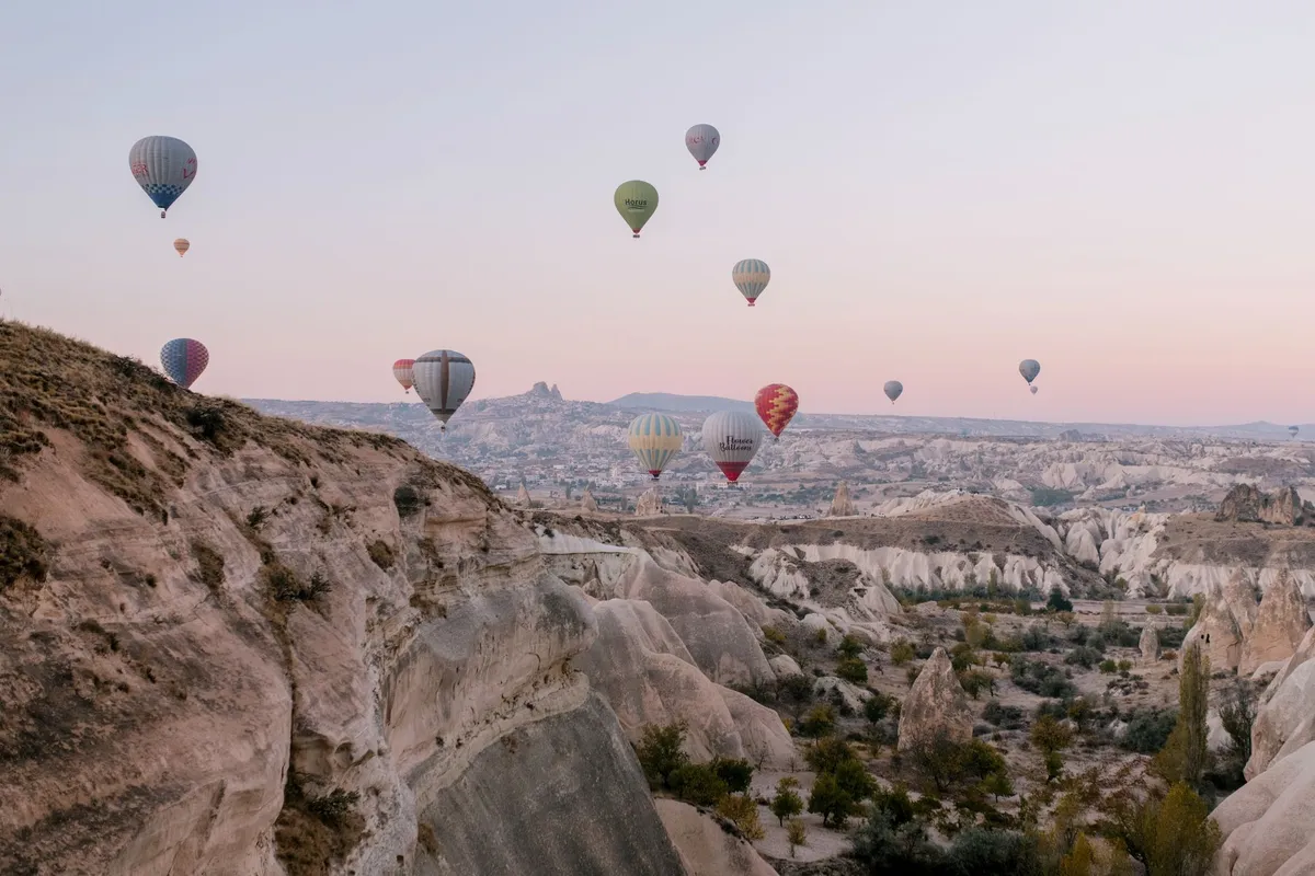 Воздушные шары Royal Balloon Cappadocia над долинами Каппадокии на рассвете